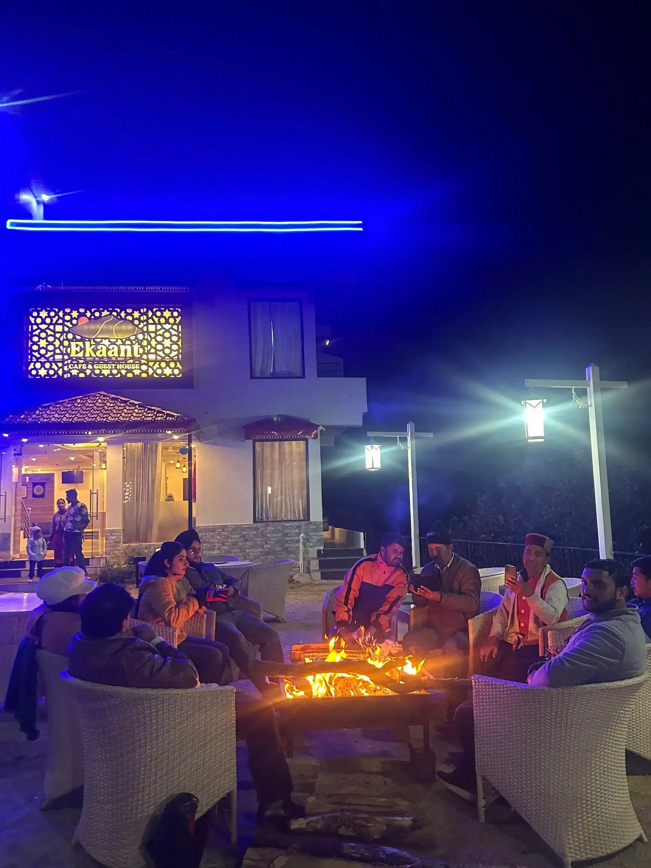 The bonfire lit on the lawn at night, with guests around it