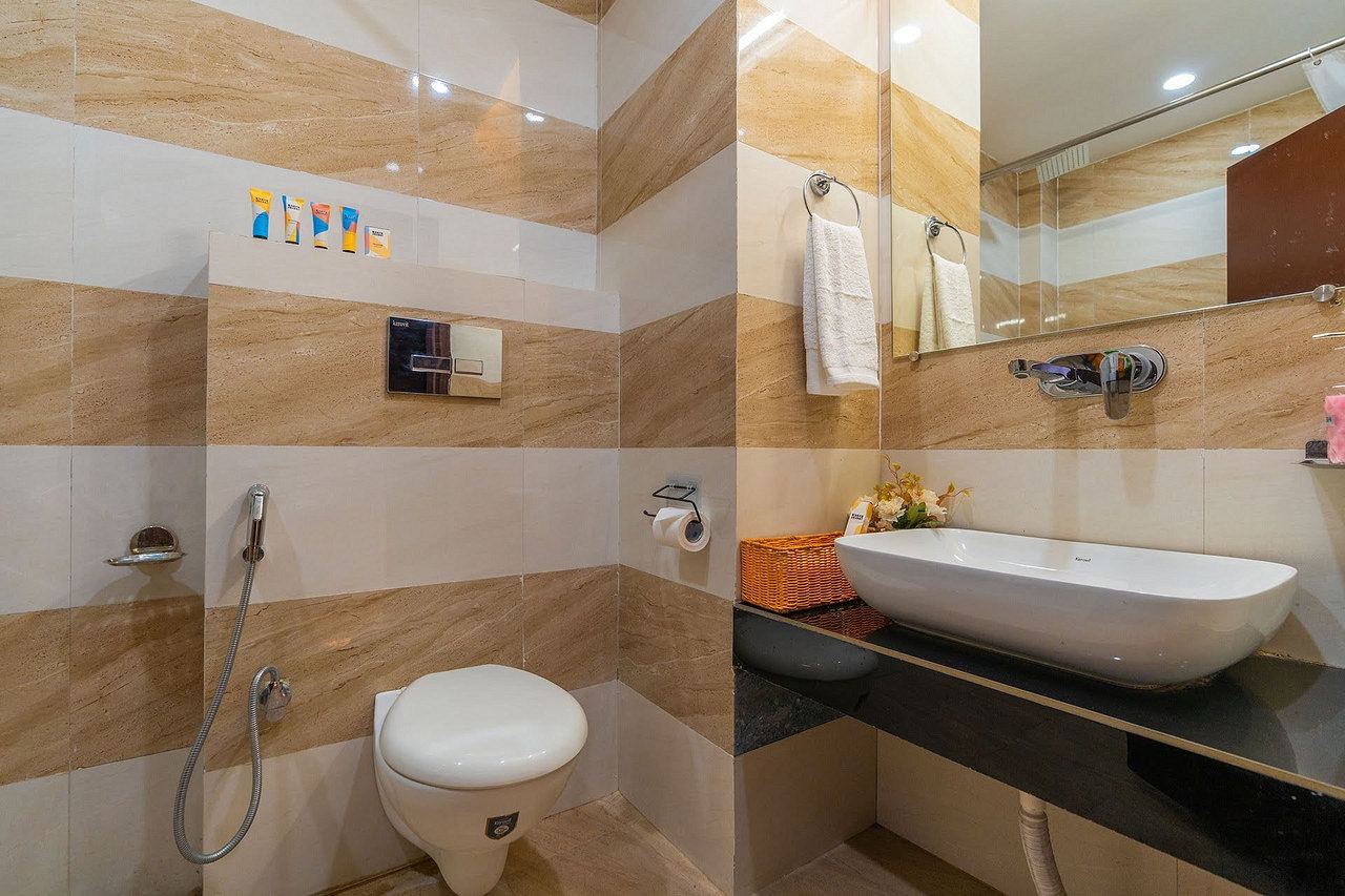 Bathroom with striped tiles, a vessel basin and a hand shower