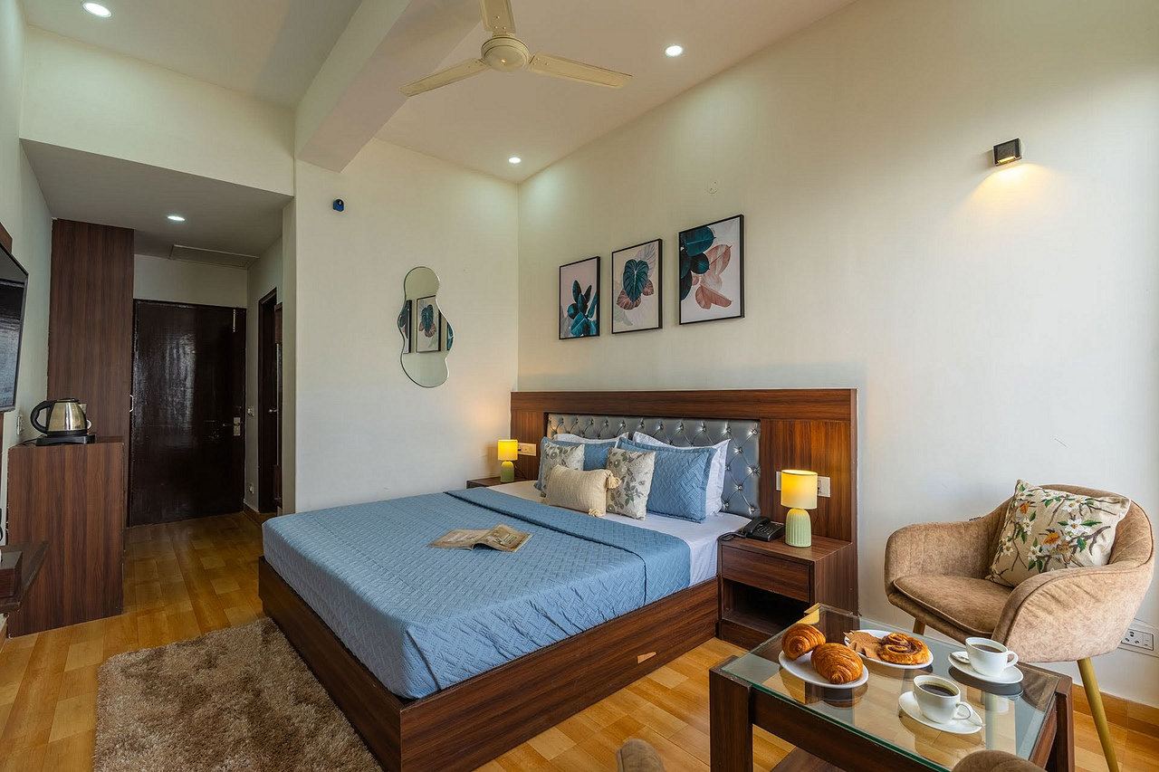 Tea, coffee and fresh pastries on a glass table beside the bed