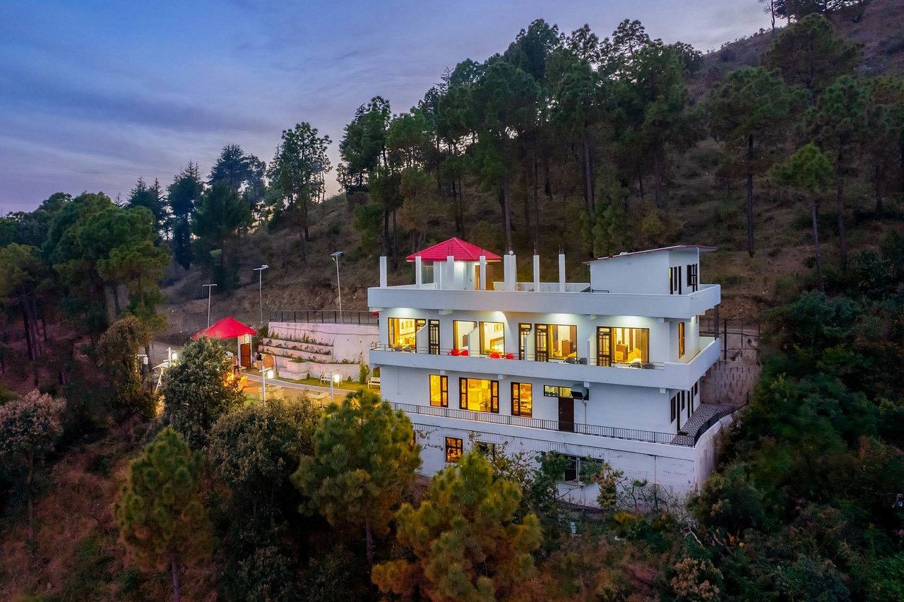 The building lit up at dusk among the forest