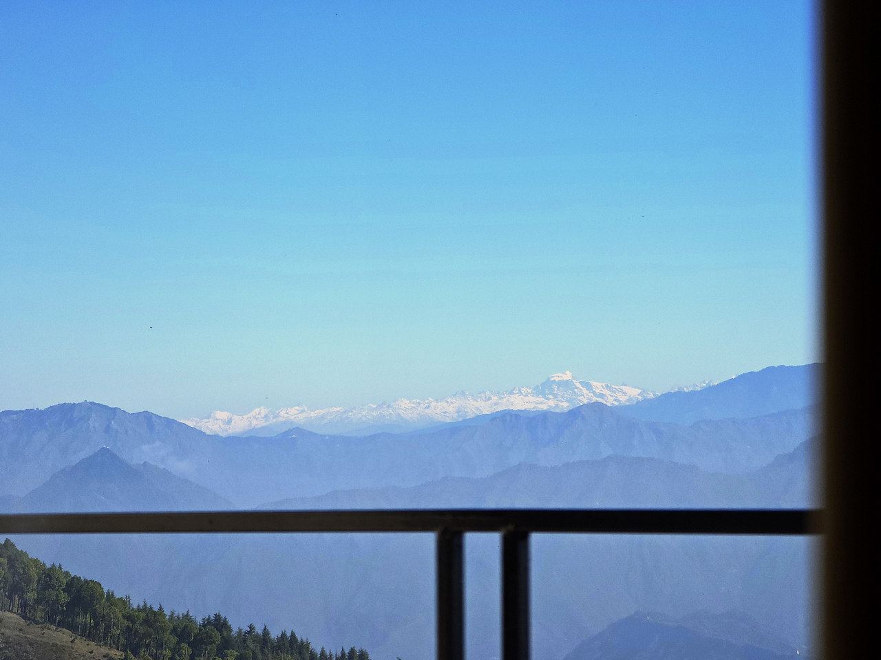 Snow peaks beyond the balcony rail