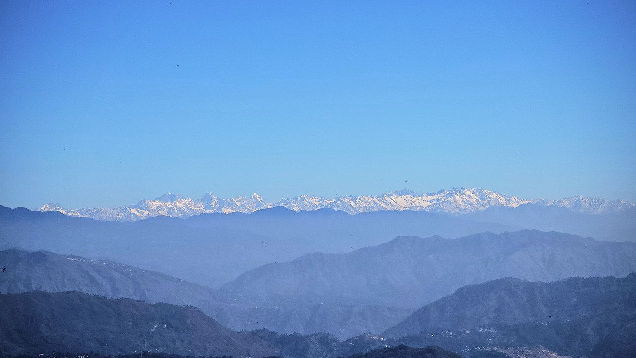 Snow peaks of the Himalaya at first light above the blue ridges