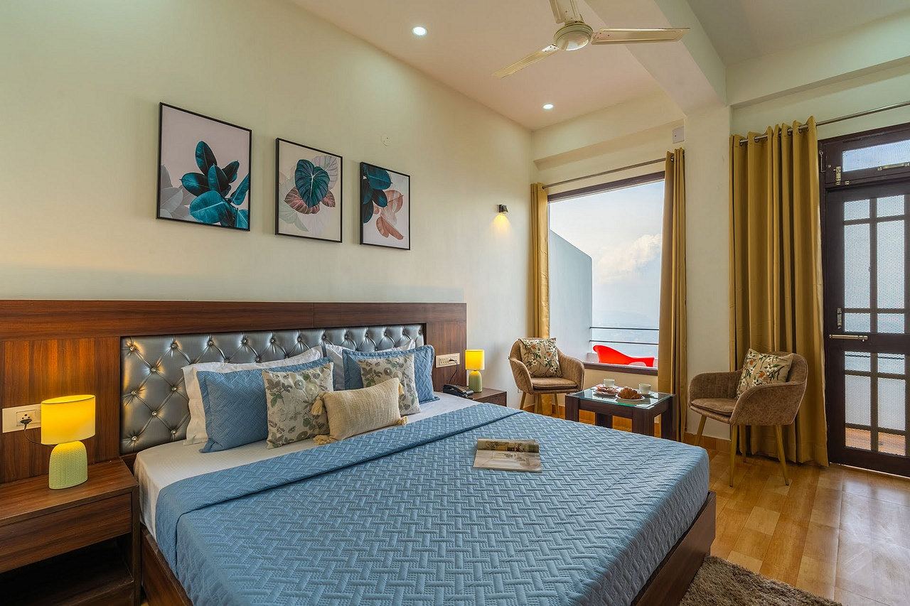 Deluxe Room with a king bed, a window onto the mountains and two armchairs